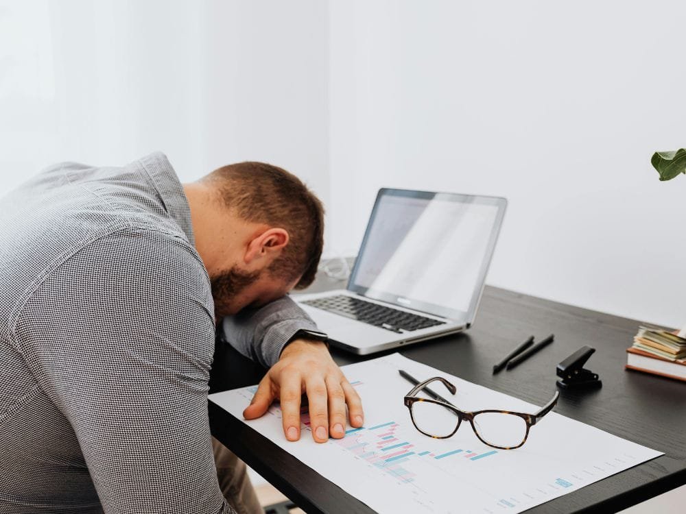 Pessoa trabalhando no marketing digital com foco perdido e distrações representando procrastinação